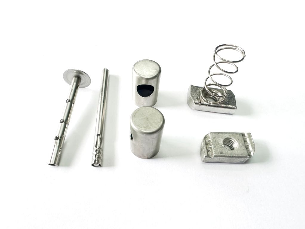 A selection of stainless steel pins, springs, and cylindrical components for industrial machinery.