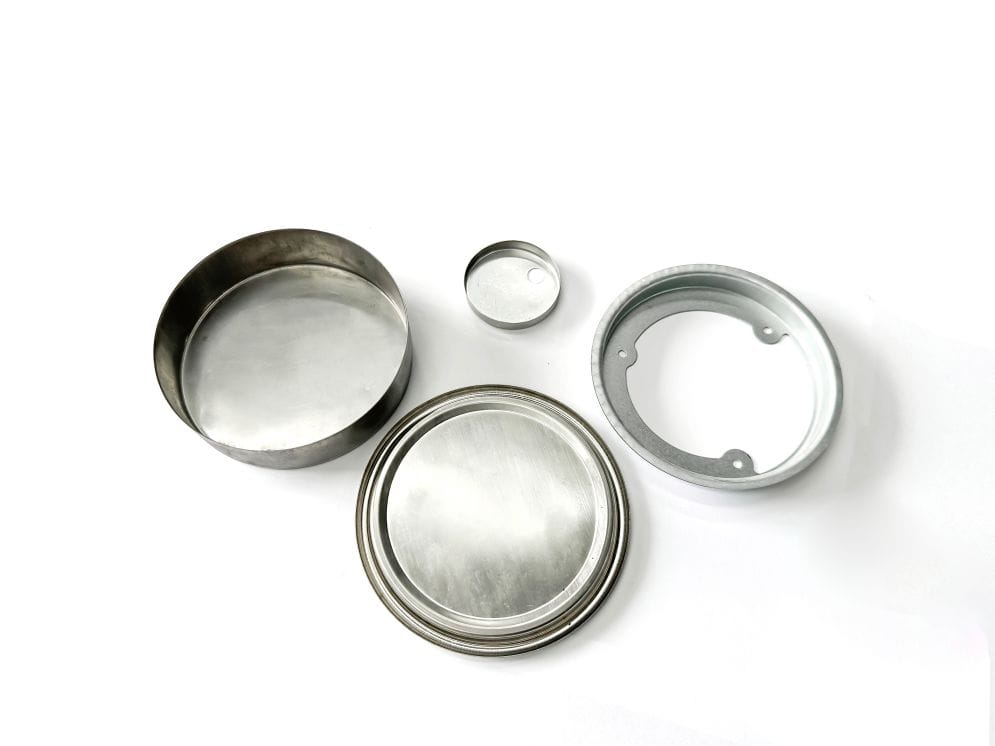 Stainless steel stamped round components, including lids and rings, used in industrial manufacturing